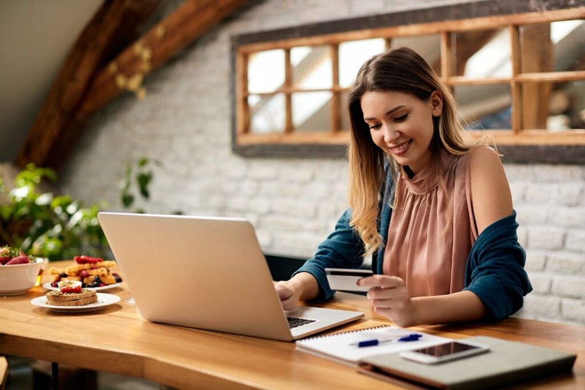 A woman uses a credit card to make an online purchase