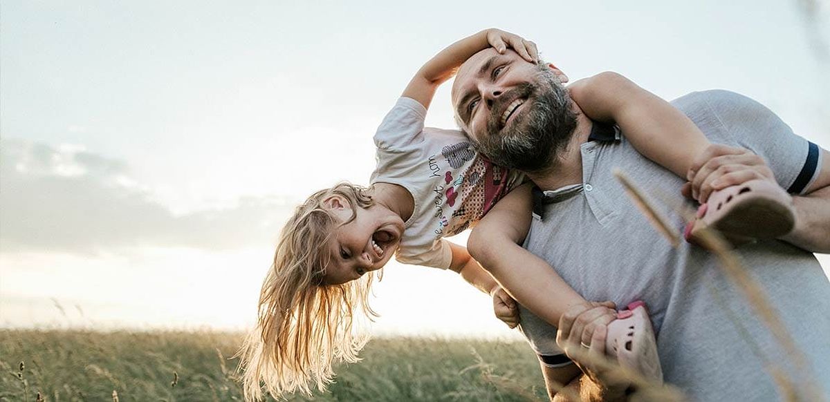 Father and daughter playing outside, symbolizing financial freedom