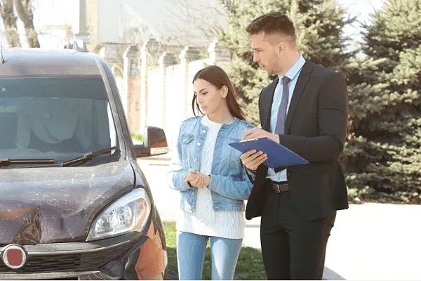 Insurance adjusters inspecting a car accident scene, highlighting the role of insurance companies in accident claims.