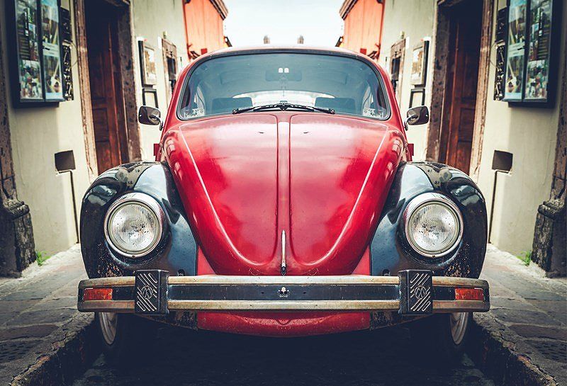 Red classic car on narrow street